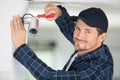 Handyman fixing cctv camera to wall Royalty Free Stock Photo