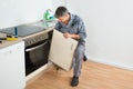 Handyman Fixing Sink Door In Kitchen