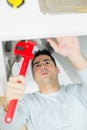 handyman fixing sink with pilers