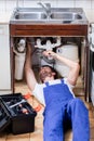 Handyman fixing a sink with pilers