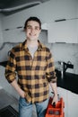 Handyman holding tools standing in kitchen. Professional plumbing services Royalty Free Stock Photo