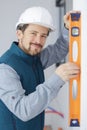 Handyman holding water level Royalty Free Stock Photo