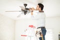 Handyman installing a ceiling fan Royalty Free Stock Photo