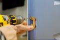 Handyman installing the door lock in the worker& x27;s hands new door locker Royalty Free Stock Photo