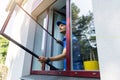 Handyman installing mosquito net mesh screen on house window