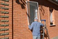 Handyman installing mosquito net screen on house window Royalty Free Stock Photo