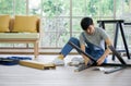 Handyman installing wooden bench in new house. House renovation service. Morning work atmosphere in the living room