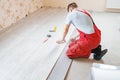 Handyman laying down laminate flooring boards