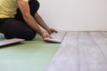 Handyman laying down laminate flooring boards while renovating a house. hands closeup Royalty Free Stock Photo