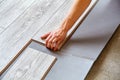 Handyman`s hands laying down laminate flooring boards Royalty Free Stock Photo