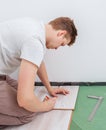 Handyman making a mark on laminate plank