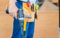 Handyman manual worker in tools belt and holding drill in his hands, Carpenter working with equipment in wood workshop, man doing Royalty Free Stock Photo