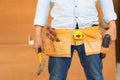 Handyman manual worker in tools belt and holding drill in his hands, Carpenter working with equipment in wood workshop, man doing Royalty Free Stock Photo