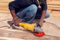 A handyman polishing wooden plank outdoor