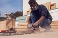 A handyman polishing wooden plank outdoor