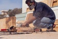 A handyman polishing wooden plank outdoor