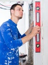 Handyman measuring angle of wall with level Royalty Free Stock Photo