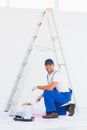 Handyman in overalls opening paint can at home Royalty Free Stock Photo