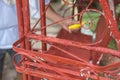 A handyman paints old glider swing made of wrought iron with red oxide primer paint. Restoring or rebuilding outdoor furniture or Royalty Free Stock Photo