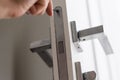A handyman repair the door lock in the room. The concept repair yourself. Selective focus Royalty Free Stock Photo