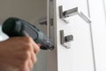 A handyman repair the door lock in the room. The concept repair yourself. Selective focus Royalty Free Stock Photo