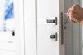 A handyman repair the door lock in the room. The concept repair yourself. Selective focus Royalty Free Stock Photo