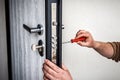 Handyman repair the door lock in metal entrance door, Man fixing lock with screwdriver Royalty Free Stock Photo