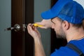 Handyman repair the door lock in the room. Closeup of man repairing the doorknob. Royalty Free Stock Photo