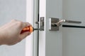 A handyman repair the door lock in the room. The concept repair yourself. Selective focus. Royalty Free Stock Photo
