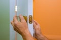 handyman repair the door lock in worker& x27;s hands installing new door locker Royalty Free Stock Photo