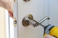 handyman repair the door lock in worker& x27;s hands installing new door locker Royalty Free Stock Photo