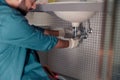Close up of plumber is repairing faucet of a sink at bathroom. Good quality plumbing company service Royalty Free Stock Photo