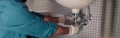 Close up of plumber is repairing faucet of a sink at bathroom. Good quality plumbing company service