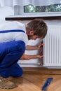 Handyman repairing radiator Royalty Free Stock Photo