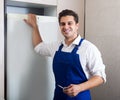 Handyman repairing refrigerator in kitchen Royalty Free Stock Photo