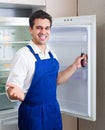 Handyman repairing refrigerator in kitchen Royalty Free Stock Photo