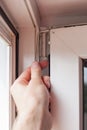 Handyman repairs plastic window with a hexagon. Workman adjusts the operation of the plastic window Royalty Free Stock Photo