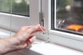 Handyman repairs plastic window with a hexagon. Workman adjusts the operation of the plastic window