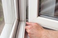 Handyman repairs plastic window with a hexagon. Workman adjusts the operation of the plastic window Royalty Free Stock Photo
