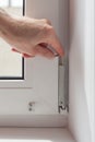 Handyman repairs plastic window with a hexagon. Workman adjusts the operation of the plastic window Royalty Free Stock Photo