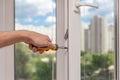 Handyman repairs plastic window with screwdriver.