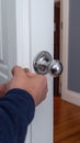 A handyman replacing old doorknobs with sleek modern designs. Royalty Free Stock Photo