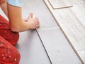 Handyman`s hands laying down laminate flooring boards Royalty Free Stock Photo