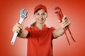 Handyman services - handy woman in red uniform with repair tools in hands on red background