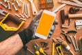 Handyman smartphone app, repairman holding mobile phone in hand