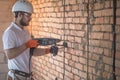 Handyman uses jackhammer, for installation, professional worker on the construction site. The concept of electrician and handyman