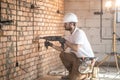 Handyman uses jackhammer, for installation, professional worker on the construction site. The concept of electrician and handyman