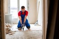 Handyman during work of removing old flooring