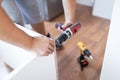 Close up of man holding electrical battery screwdriver while installing wooden kitchen shelves Royalty Free Stock Photo