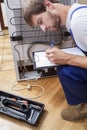 Handyman working with a broken fridge